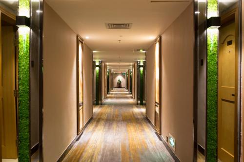 a corridor of a building with plants on the walls at Shenzhen Kaili Hotel, Guomao Shopping Mall in Shenzhen