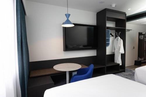 a room with a bed and a table and a tv at Bayside Geelong Hotel & Apartments, an Ascend Collection Hotel in Geelong