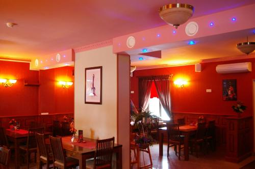 a restaurant with red walls and wooden tables and chairs at Veski Guesthouse in Antsla