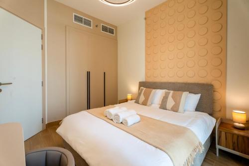 a bedroom with a bed with towels on it at Comfortable 1 Bedroom with Balcony Vista 1 in Abu Dhabi
