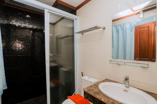 a bathroom with a toilet and a sink and a shower at Vilayvong Hotel in Vang Vieng