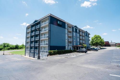 a large building with a parking lot in front of it at MainStay Suites Knoxville North I-75 in Knoxville