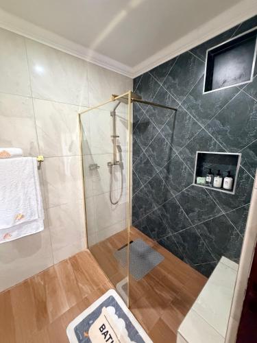 a bathroom with a shower with a glass door at 10 on Pauling Hotel Bulawayo in Bulawayo