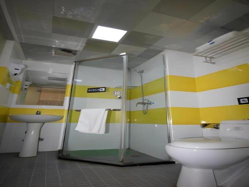 a bathroom with a shower and a toilet and a sink at 7 Days Inn Yantai Dahaiyang Raod Railway Station in Yantai