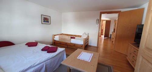 a bedroom with a bed and a table and a television at Haus Johanneshof 1604 in Lech am Arlberg