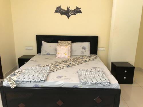 a bed with a black headboard and pillows on it at TT Homes Homestay for Cozy Family Stay in Jaipur in Jaipur