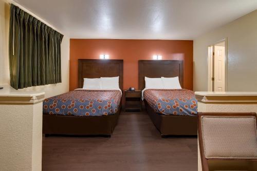 een hotelkamer met twee bedden en een raam bij Rodeway Inn & Suites New Orleans East in New Orleans