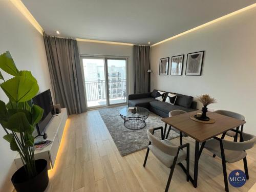 a living room with a couch and a table at Spacious 2BR Yas island Pool, Gym, Parking in Abu Dhabi