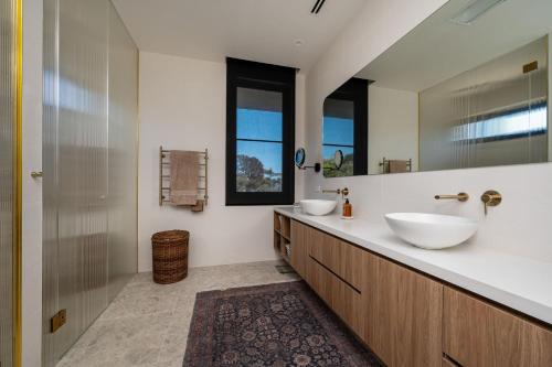 Un baño con dos lavabos y un espejo. en The Crest - Elevated Luxe with Pool & Spa, en Mount Martha