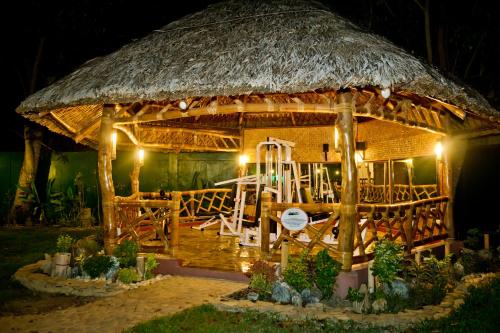 a large bamboo hut with a table and chairs in it at Dolce Vita Hotel in Puerto Princesa City