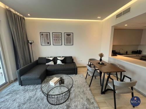 a living room with a couch and a table at Spacious 2BR Yas island Pool, Gym, Parking in Abu Dhabi