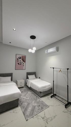 a bedroom with two beds and a rug at Luxury 2BR Apartment -Prime Area in Jeddah