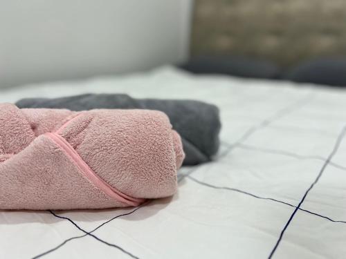 une serviette rose posée sur le sol dans une pièce dans l'établissement Mojisu Homestay 麻吉宿, à Miri
