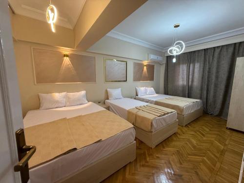 Una habitación de hotel con dos camas y una ventana. en Grand Royal central Cairo Home, en El Cairo