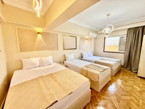 una habitación con dos camas y un sofá en Grand Royal central Cairo Home, en El Cairo