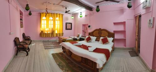 a bedroom with a large bed in a pink room at Hotel Nomadic Haveli in Jaisalmer
