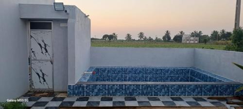 a plunge pool with blue tile on a white wall at Om Villa in Mandvi