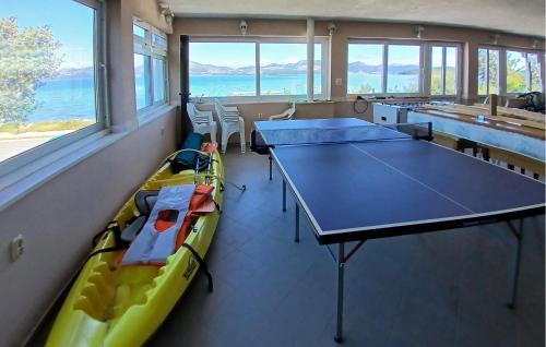 Una habitación con dos mesas y un kayak dentro. en Amazing Apartment In Janjina With Lake View, en Drače
