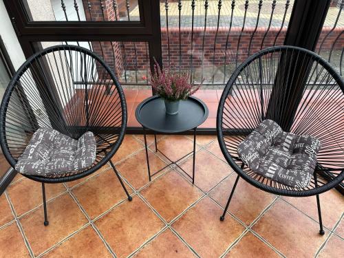 two chairs and a table in front of a window at Akme APARTMENTS & ROOMS & FREE PARKING in Gdańsk
