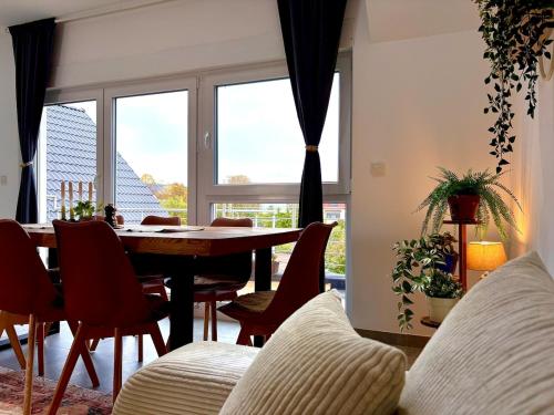 a dining room with a table and chairs and a window at Vollausgestattetes & harmonisches Wohlfühl Apartment in Saarbrücken