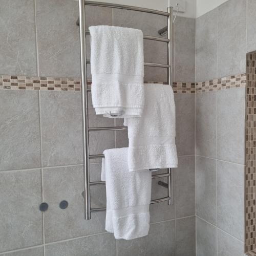 a shower with white towels on a rack in a bathroom at Miss Victoria in Nerrina