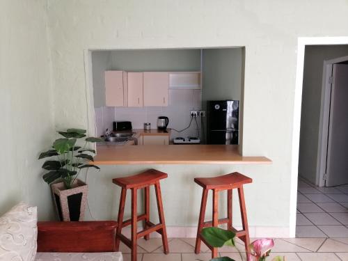 cocina con encimera y 2 taburetes en Falcon Nest, en Kenton on Sea