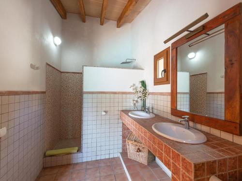 a bathroom with two sinks and a mirror at Finca s'Aguait in Portocolom