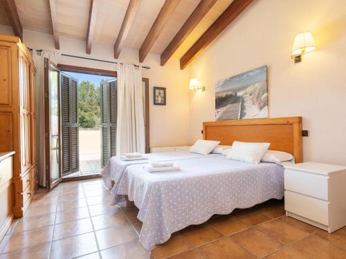 a bedroom with a bed and a large window at Finca s'Aguait in Portocolom