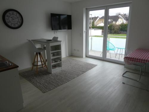 a living room with a table and a tv and a door at Ferienwohnung Bella in Koblenz