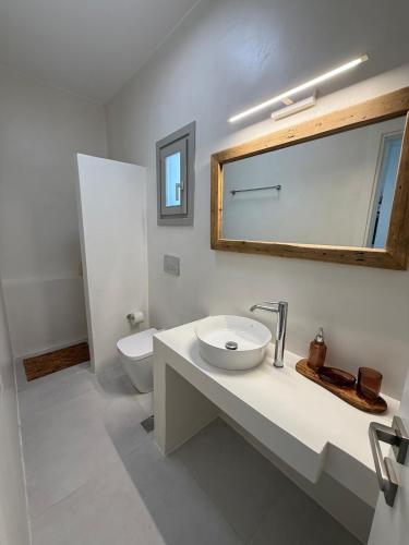 a bathroom with a sink and a toilet and a mirror at Elenitsa Villa with private pool in Aliki