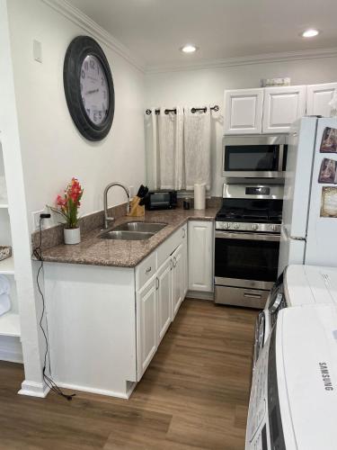 a kitchen with a sink and a clock on the wall at Two bedroom private guesthouse in great location Close to Melrose Hollywood sign and attractions in Los Angeles