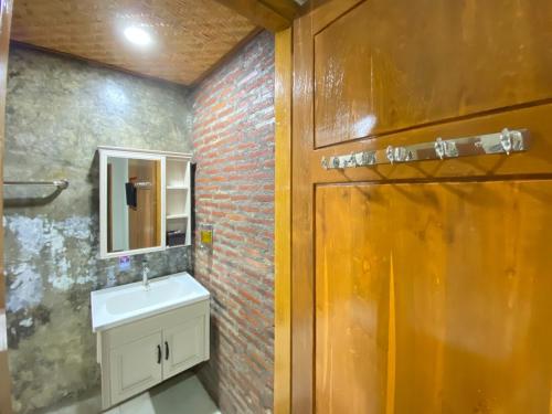 プロボリンゴにあるRedDoorz at The Canal Homestay Probolinggoのレンガの壁、洗面台付きのバスルーム