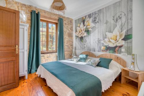 a bedroom with a bed and a painting of flowers at Gîte Jasmin in Plavilla