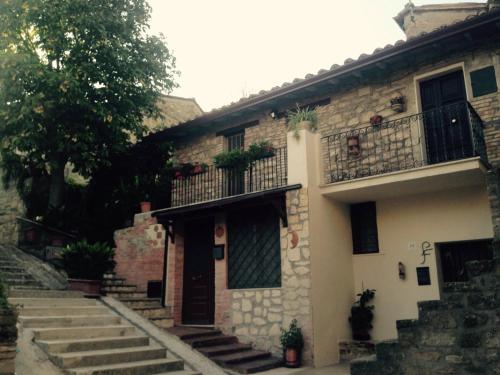 PianelloにあるResidenza Etruscaの階段とバルコニー付きの古い石造りの家