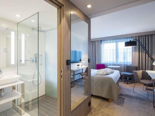 ein Hotelzimmer mit einem Bett und einem Badezimmer in der Unterkunft Mercure Krakow Stare Miasto in Krakau