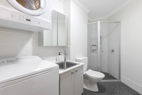 a white bathroom with a sink and a toilet at Quest on Rheola in Perth