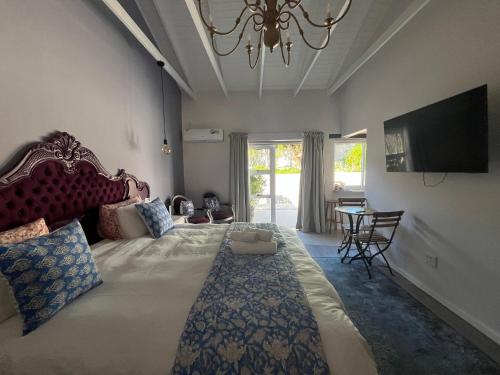サマーセット・ウェストにあるThe Botanical Houseの大きなベッドルーム(大型ベッド1台、シャンデリア付)