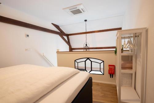 a bedroom with a bed and a window at B&B De Hoffstal in Sassenheim