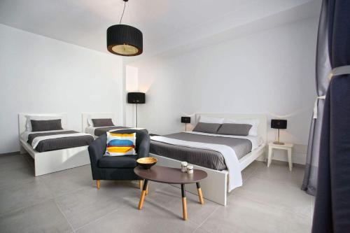 een slaapkamer met een bed, een bank en een stoel bij B&B Roda Barocco in Noto