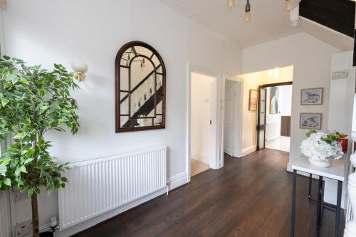 a hallway with white walls and a mirror on the wall at Modern 4 Bedroom Victorian Property Private Detached Close to Manchester City in Manchester