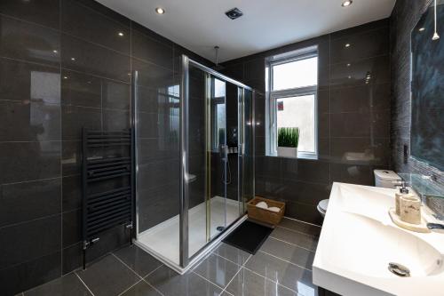 a bathroom with a shower and a sink at Modern 4 Bedroom Victorian Property Private Detached Close to Manchester City in Manchester