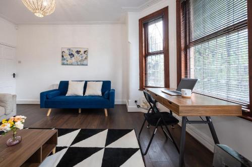 a living room with a desk and a blue chair at Modern 4 Bedroom Victorian Property Private Detached Close to Manchester City in Manchester