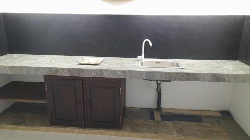 a kitchen counter with a sink in a room at The Belle Denipitiya in Welihinda