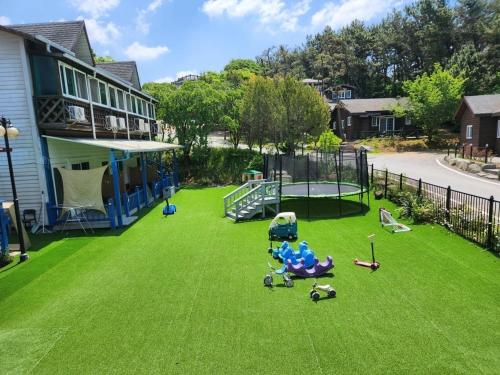 a yard with a playground with toys on the grass at Taean Lily Pension in Taean