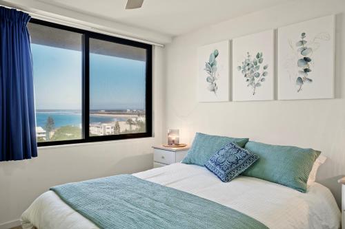 a bedroom with a bed with a view of the ocean at Burgess @ Kings Beach Apartments in Caloundra