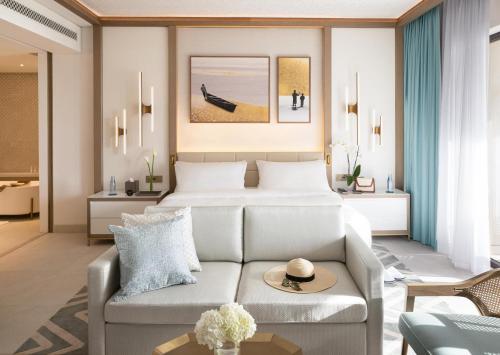 a hotel room with a bed and a couch at Jumeirah Gulf of Bahrain in Manama