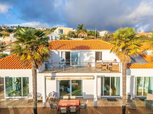 an aerial view of a house with palm trees at Magnolia Sunsets in Calheta