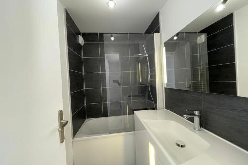 a bathroom with a sink and a shower with a mirror at Le ciel havrais in Le Havre