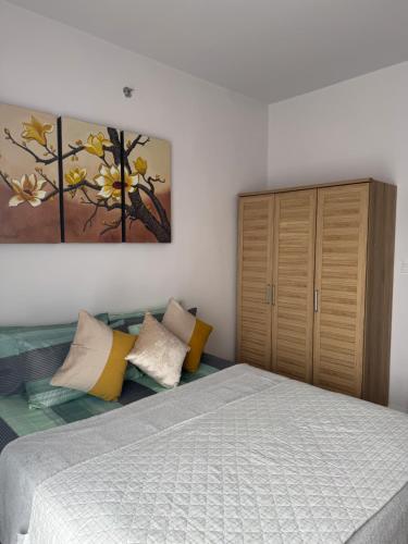 a bedroom with a bed and a painting on the wall at Mira's condo unit at Amani grand residences near Mactan Int'l Airport in Pusok