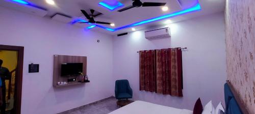 a room with a ceiling fan and blue lights at Kashi Satya Luxury Stay in Varanasi
